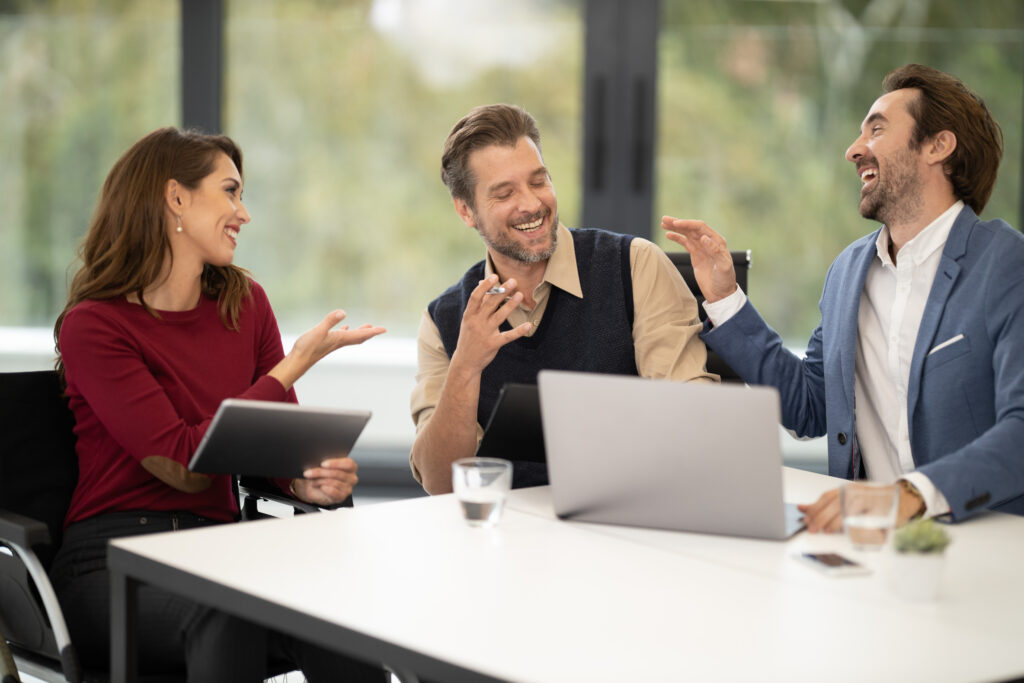 Menschen im Business Gespräch an einem Tisch mit Laptop